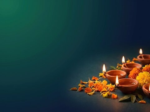 Diwali corporate website header with lit clay diyas and marigold petals on dark green gradient background for banner and hero section