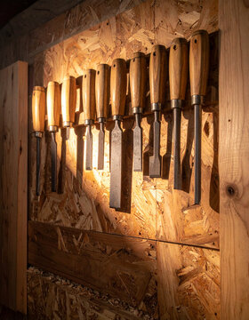 Hanging tool wall with chisels and saws in vertical crop with warm side light generative AI