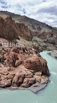 Zanskar, India : Panoramic footage of tsarap river in Lungnak valley with Phuktal gompa in the background, cliffside monastery built in natural cave of Zanskar in Ladakh in northern India 