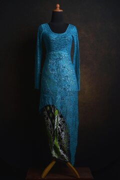 Blue Asymmetric Modern Indonesian Lace Kebaya with black and green batik skirt displayed on a dress form