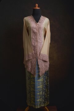 Indonesian Kebaya with Embroidered Lace Accent and Batik Skirt Displayed on A Dress Form