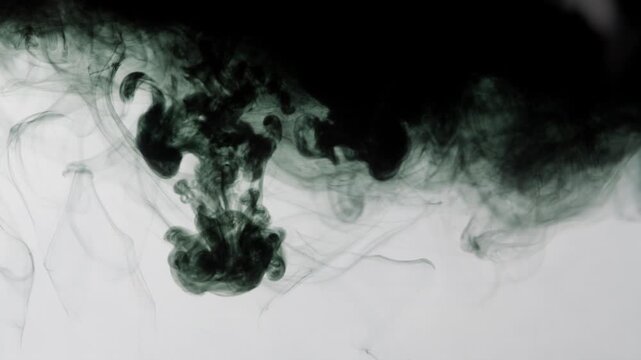 Abstract ink diffusion flowing in water on white background cinematic slow motion.