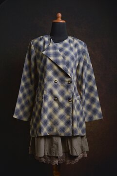 Plaid double-breasted blazer with brown layered skirt displayed on a dress form