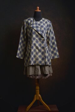 Plaid double-breasted blazer with brown layered skirt displayed on a dress form