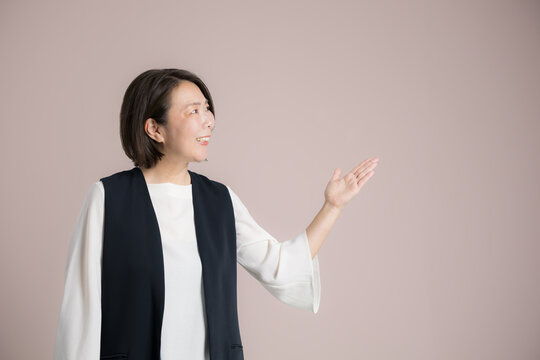 働く40代女性笑顔の手でオススメや紹介ポーズのビジネスポートレート