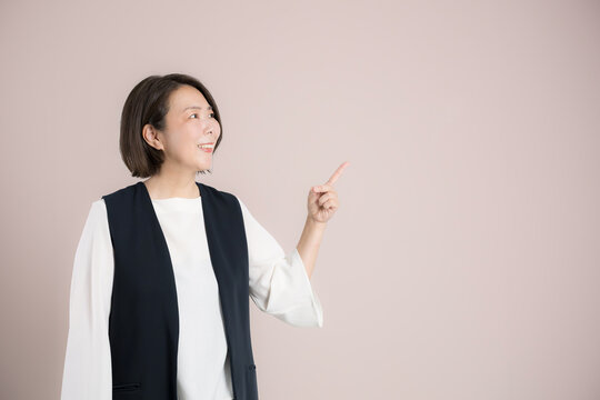 働く40代女性指を差してポイント確認、チェック笑顔のオススメポーズのビジネスポートレート