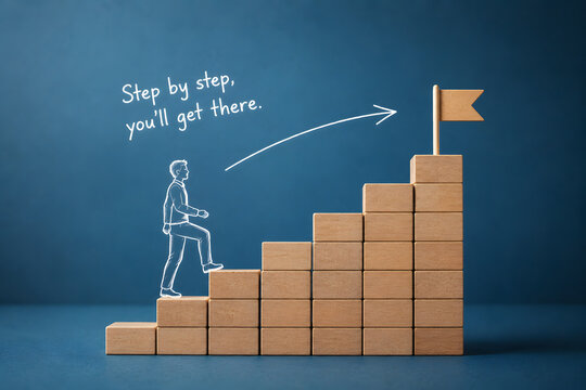 Wooden blocks form a rising staircase as a person climbs toward a flag, symbolizing progress, ambition, career growth, and achievement.
