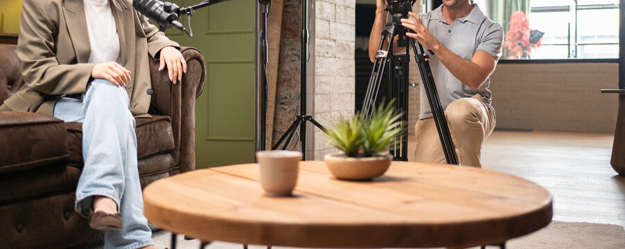 Podcast host sitting for an interview with a videographer recording the session