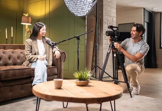 Man filming content creator talking into microphone during video production