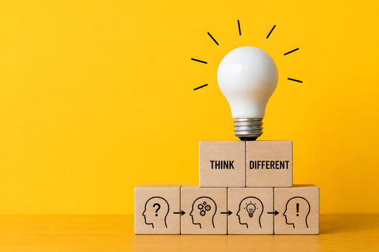 Light bulb and wooden blocks illustrate creative thinking, problem solving, innovation, and finding a different path toward new ideas.
