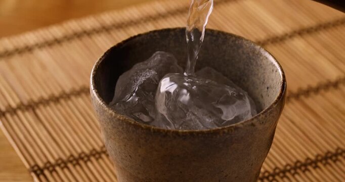 氷の入ったグラスに焼酎を注ぐ