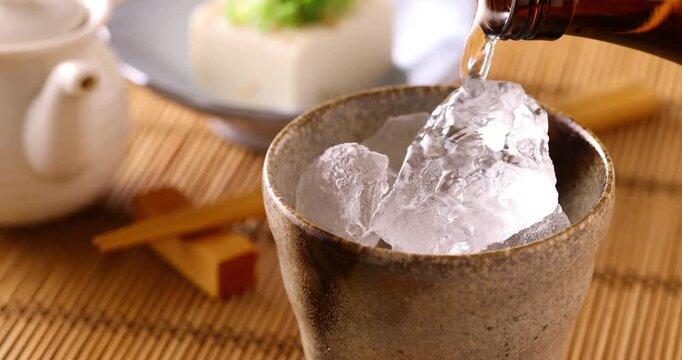 氷の入ったグラスに焼酎を注ぐ