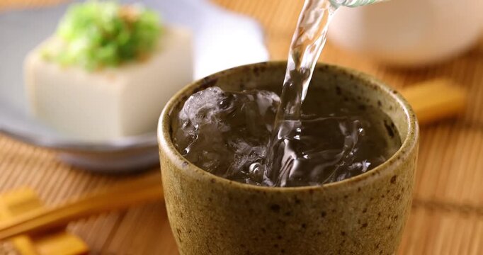 氷の入ったグラスに焼酎を注ぐ
