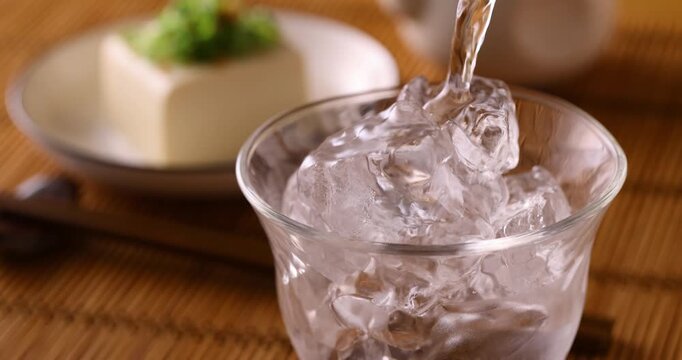 氷の入ったグラスに焼酎を注ぐ