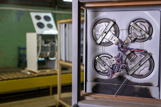 Industrial appliance assembly with exposed wiring and heating elements in factory setting