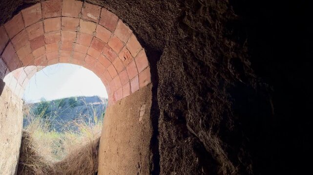 View from inside brick tunnel to hills outside, video