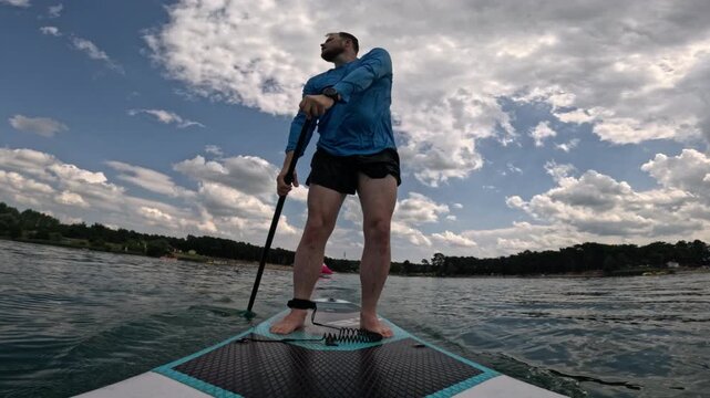 Man paddleboarding on lake