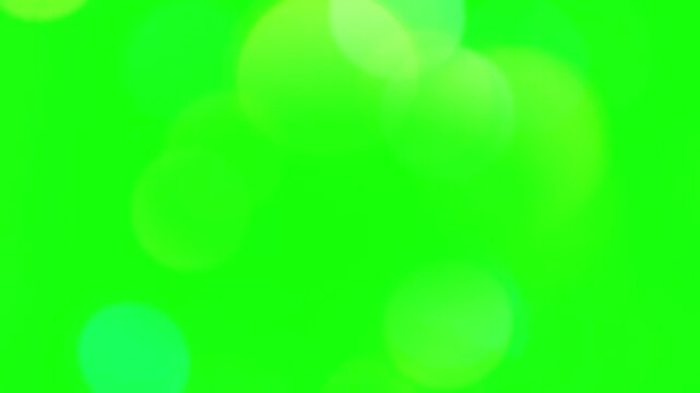Soft glowing bokeh circles float across an empty green screen backdrop designed for colorful lighting overlays.