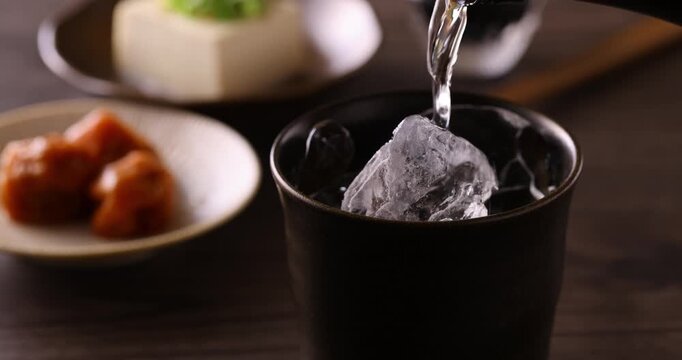 氷の入ったグラスに焼酎を注ぐ