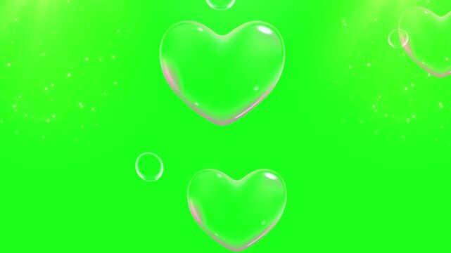 Heart shaped soap bubbles float gracefully against a solid green screen chroma key background for romantic overlays.