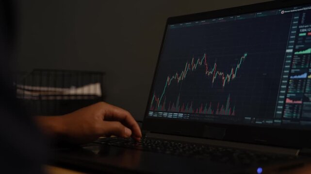 Stock crypto trader looking at computer analyzing trading crypto currency finance market crypto stock market data.