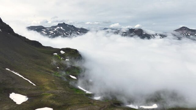 Aerial view of a rugged mountain landscape with a cloud inversion in the east of Iceland