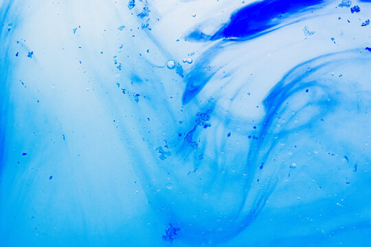 Abstract blue color dissolving in fluid water