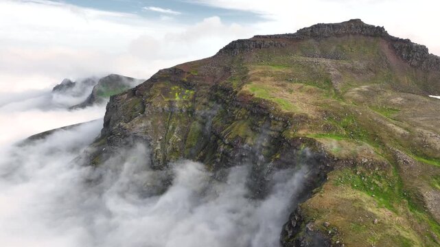 Aerial view of a rugged mountain landscape with a cloud inversion in the east of Iceland