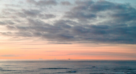 Fototapeta premium Ship and islands on the ocean horizon at sunset
