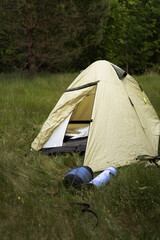 Camping tent and sleeping bags in a green field © Cavan