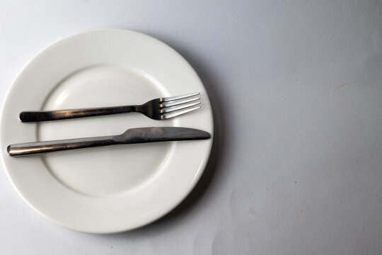 Empty plate with fork and knife on table