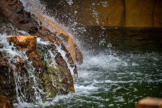 Waterfall flowing over rocks into a pond