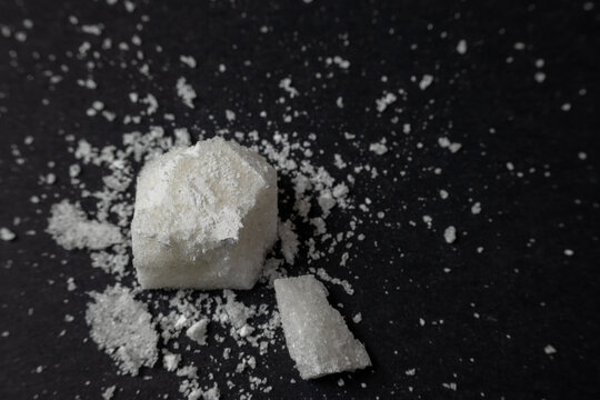 Broken sugar cube on black background