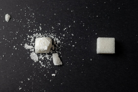 Broken sugar cube on black background