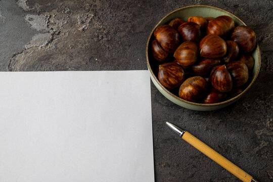 Chestnuts in bowl with pen and copy space