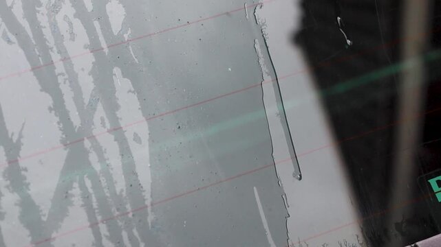 Video of water running down the back windshield of a car.