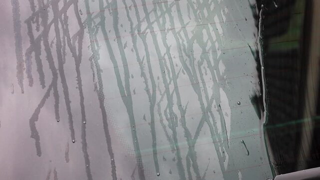 Video of water running down the window of a car.