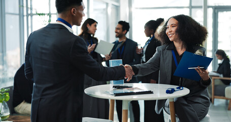 Business people, seminar or shaking hands for introduction, meeting or greeting with smile. Conference, happy or handshake for welcome, hello or innovation event with clipboard for guest registration © peopleimages.com