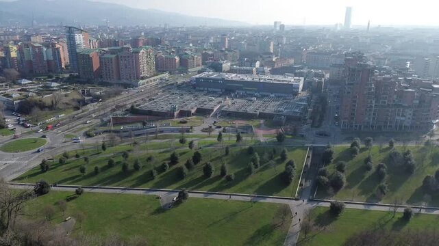 High angle drone shot over the red steel framework of Parco Dora looking towards Turin city and Alps, Piedmont, Italy