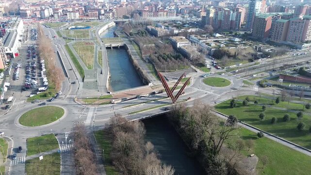 Bright daytime aerial view of Parco Dora industrial structures and Turin cityscape bounded by snowy Alpine peaks, Italy