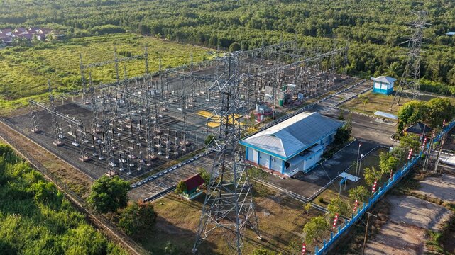 Aerial view of an electrical power substation surrounded by trees and vegetation in Indonesia