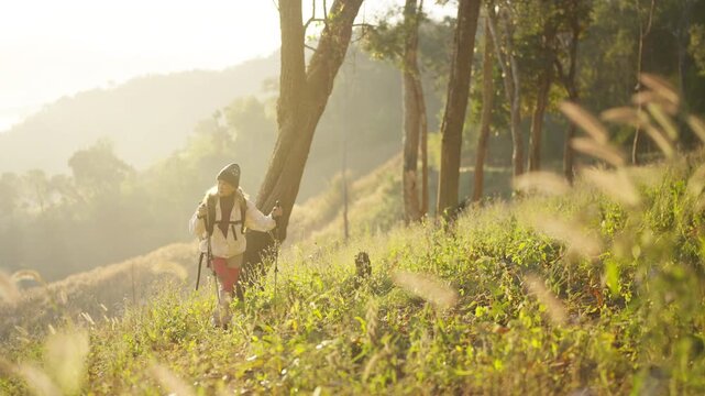 Asian mature woman travel nature hiking on mountain above cloudscape at sunrise. Female traveler with backpack enjoy outdoor active lifestyle , aging gracefully healthy wellness on holiday vacation
