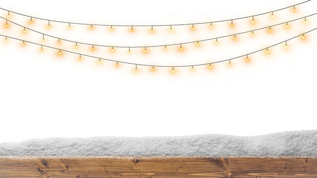 Warm glowing string lights above snow on a rustic wooden board, creating a cozy winter holiday background.