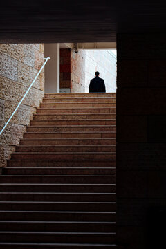 Lone figure stands at the top of stone stairs