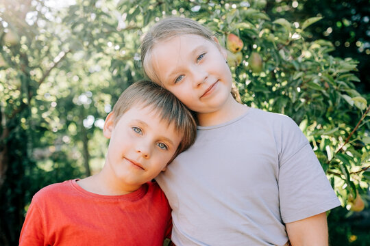 Cute siblings posing together in sunny garden