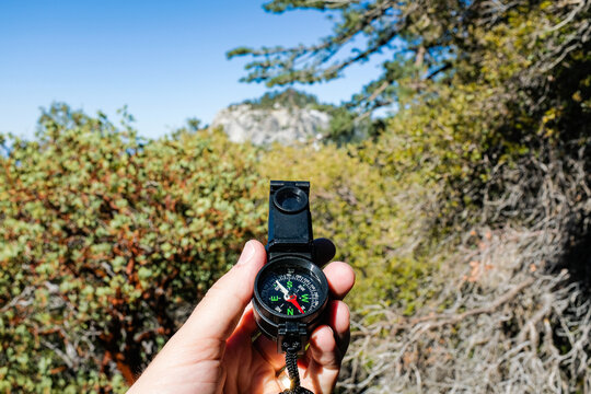 Hand holding a compass while hiking outdoors