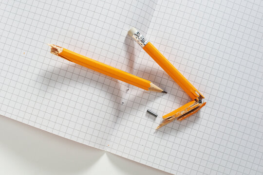 Broken Yellow Pencil on Notebook
