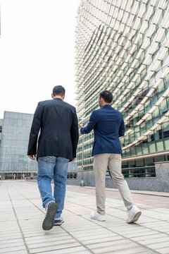 Technology startup founders walking discussing business in urban setting
