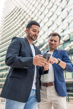 Technology startup founders discussing business with smartphone