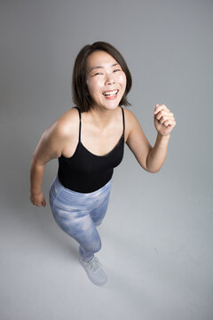 笑顔で元気にフィットネス運動を楽しむ40代の女性、更年期に健康とダイエットを意識したランニングや走る歩くトレーニングカメラ目線俯瞰
